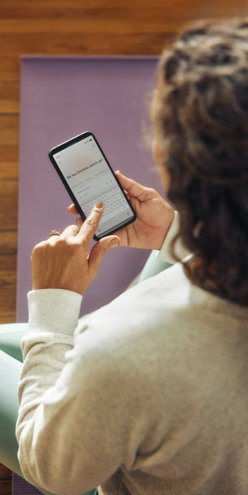 woman-using-a-smartphone-on-a-yoga-mat-.jpg Woman using a smartphone on a yoga mat.